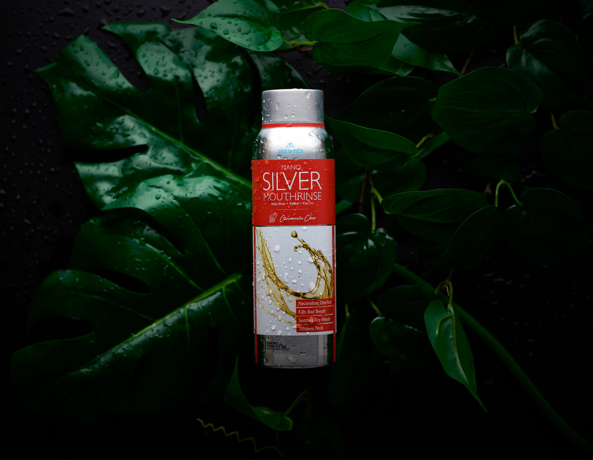 image of wet cinnamon clove mouth rinse with nano silver bottle on leaves
