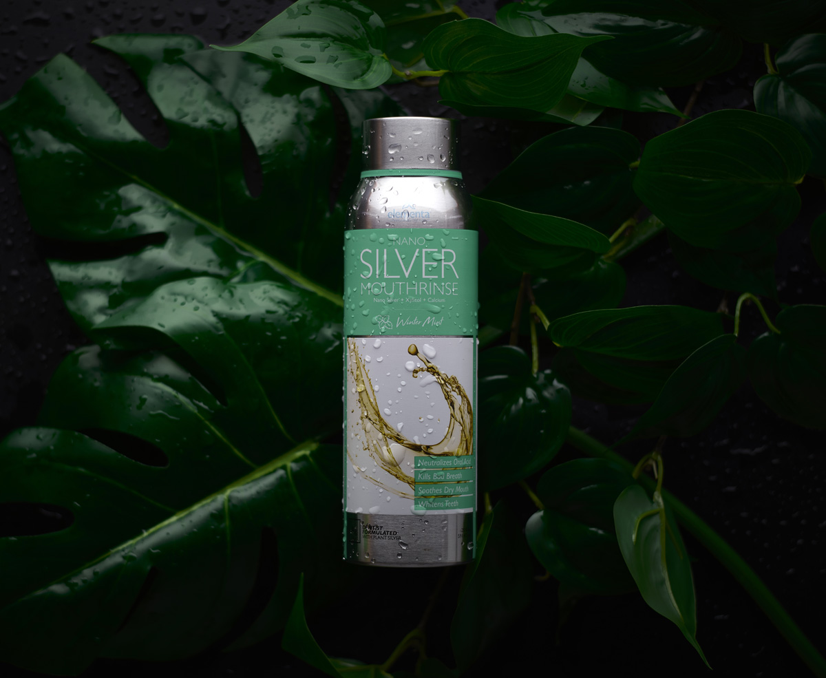 wet bottle of winter mint mouth rinse with nano silver on leaves